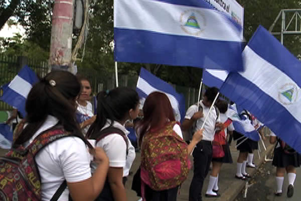 Estudiantes distribuyen banderas para promover el amor a la patria