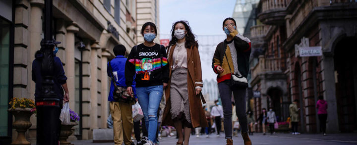 Personas con máscaras en una zona comercial después del levantamiento de las restricciones en Wuhan