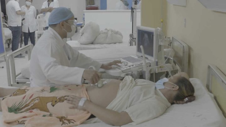 Médico realiza ultrasonido a paciente embarazada.