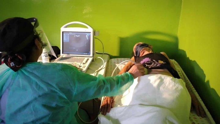Experto médico realiza ultrasonido a paciente.