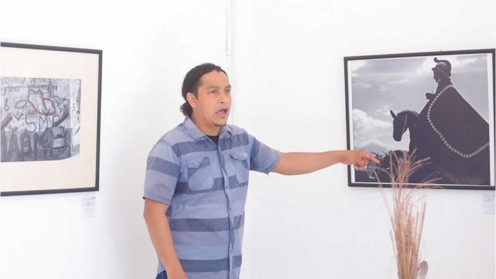 Expositor de arte, explicando cuadro artístico. 