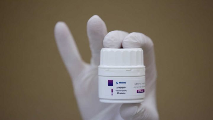 Un empleado muestra un bote con pastillas del fármaco antiviral Avifavir.