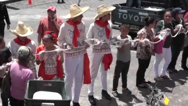 Personas sosteniendo el quesillo más grande de Nicaragua. 