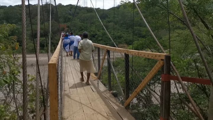 Familias cruzando el puente colgante de Mozonte.