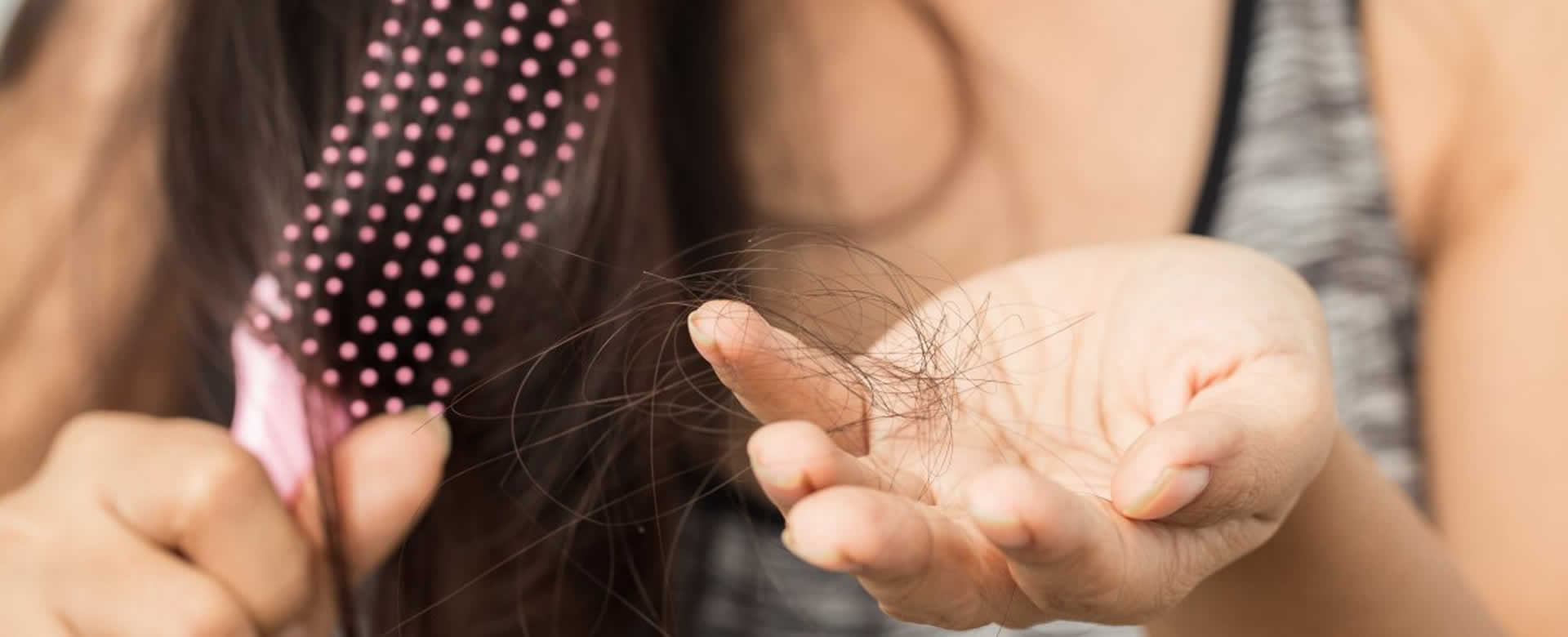 Caída abundante de cabello mientras una mujer se peina.