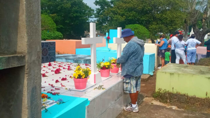 Hombre pone flores en una tumba en Carazo.